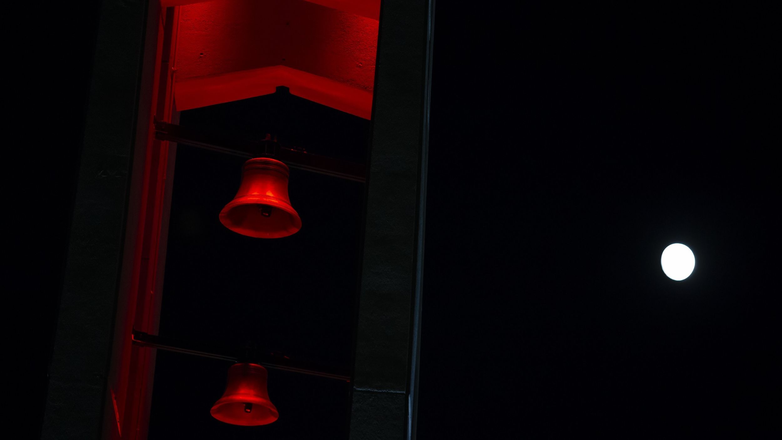 The moon shining above the Bell Tower on Main Campus.