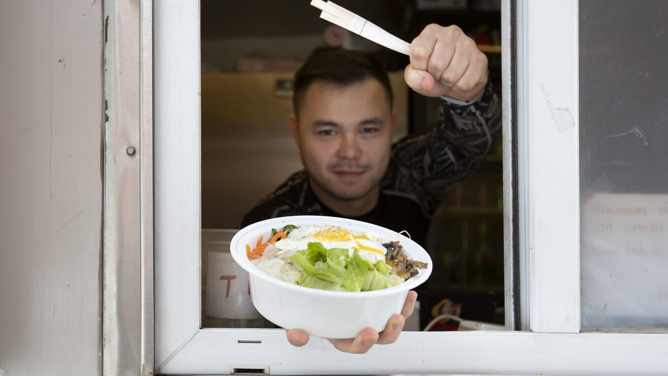 A food truck vendor shows off a meal