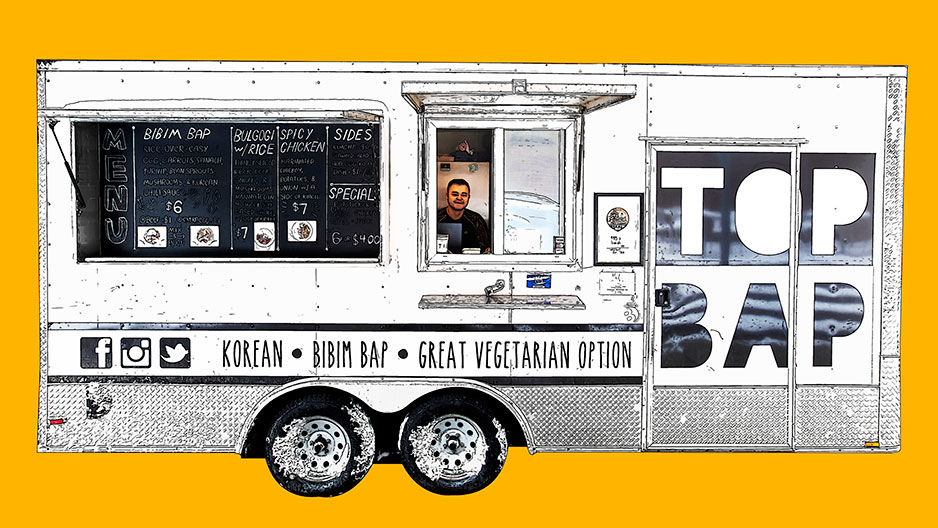 A still image of a man behind the Top Bap food truck.