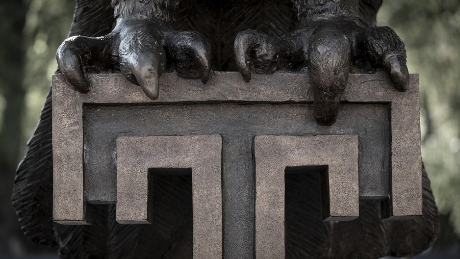 a close up of Main Campus' Owl statue's talons gripping the Temple "T" 