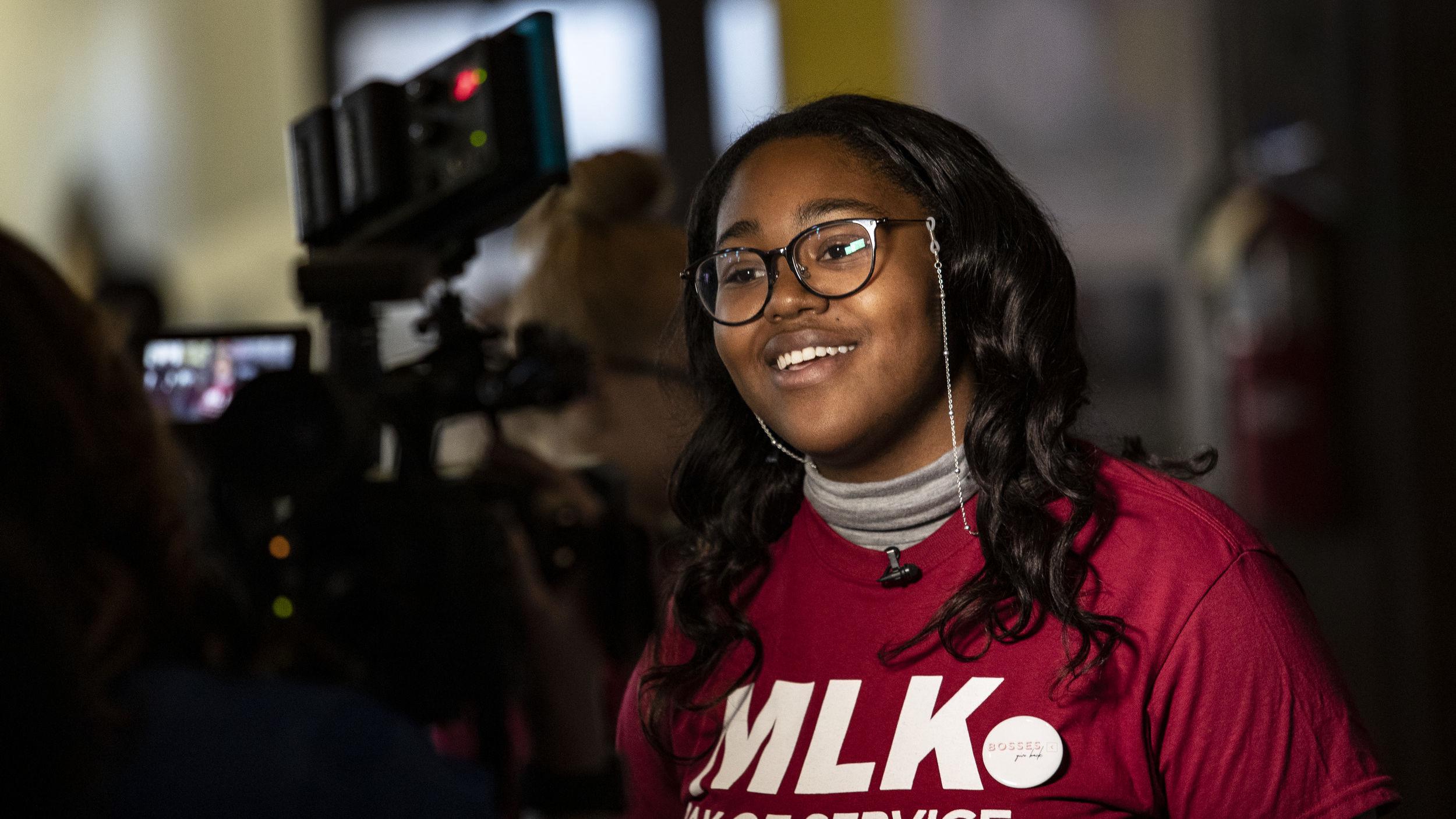 Image of a Black woman wearing a cherry and white MLK Day shirt.