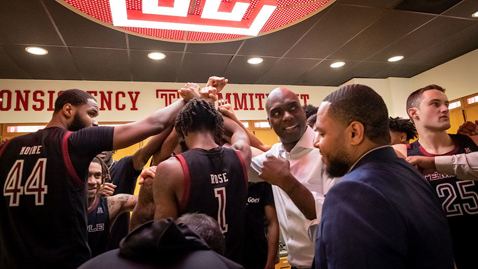 Aaron McKie and coaches, players huddle