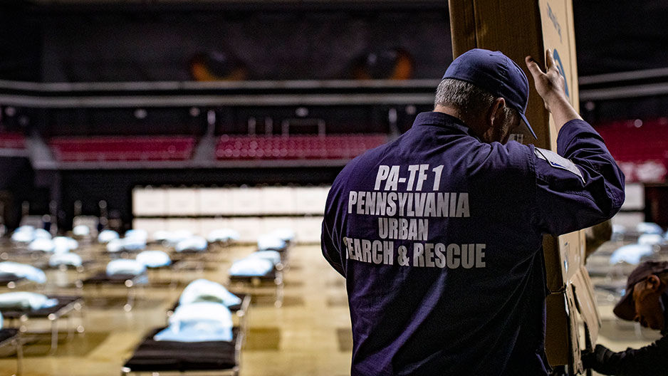 emergency worker setting up medical supplies at Liacouras Center