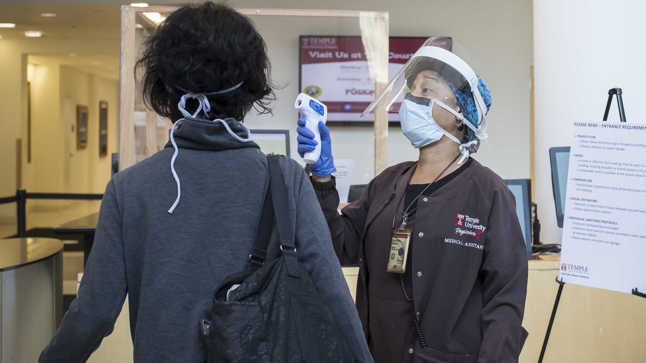 A medical assistant screening a patient