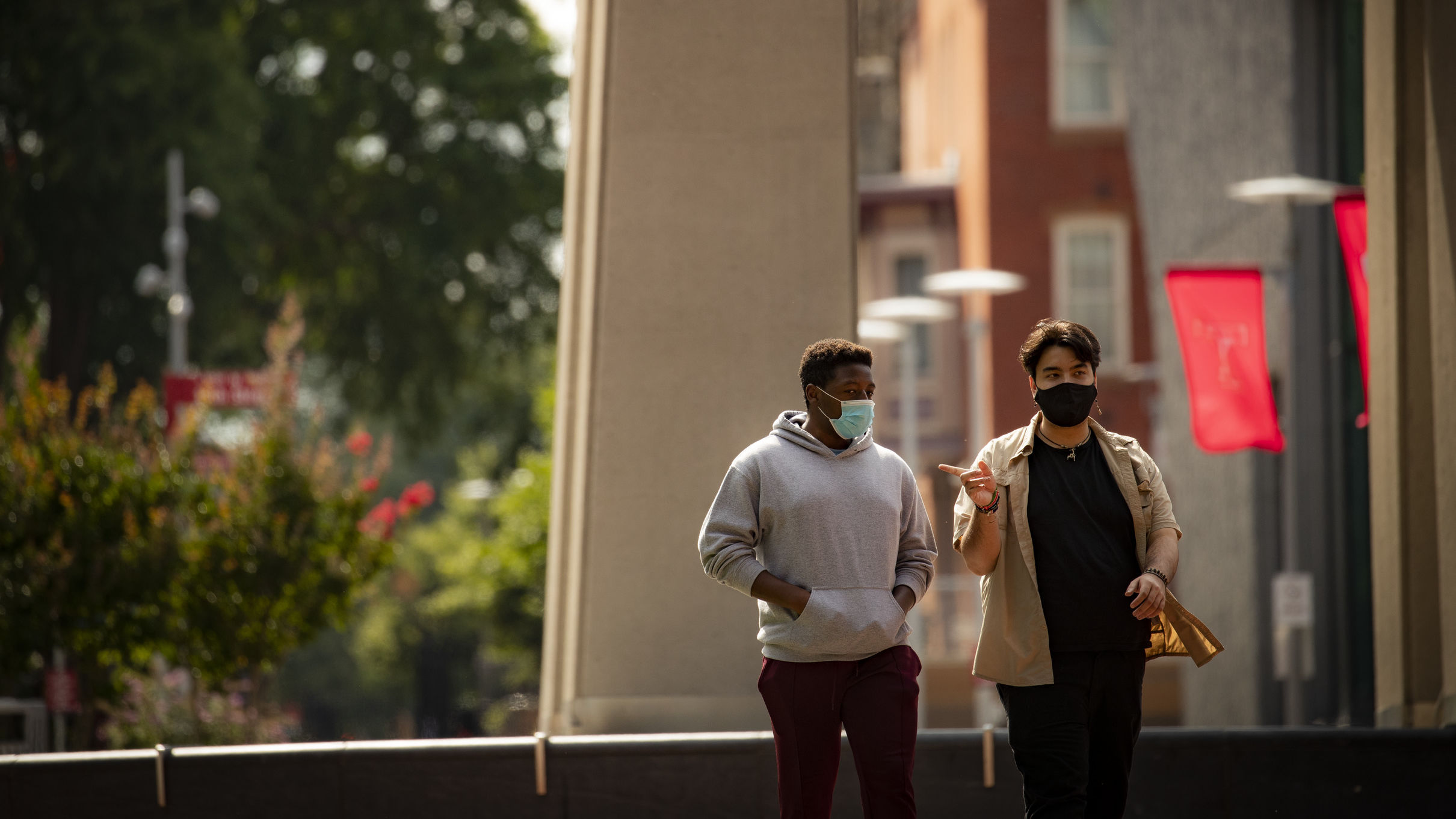 Image of two students wearing face coverings walking down Polett Walk on Main Campus.