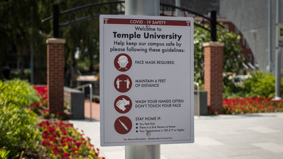 a sign on campus describing COVID-19 health precautions