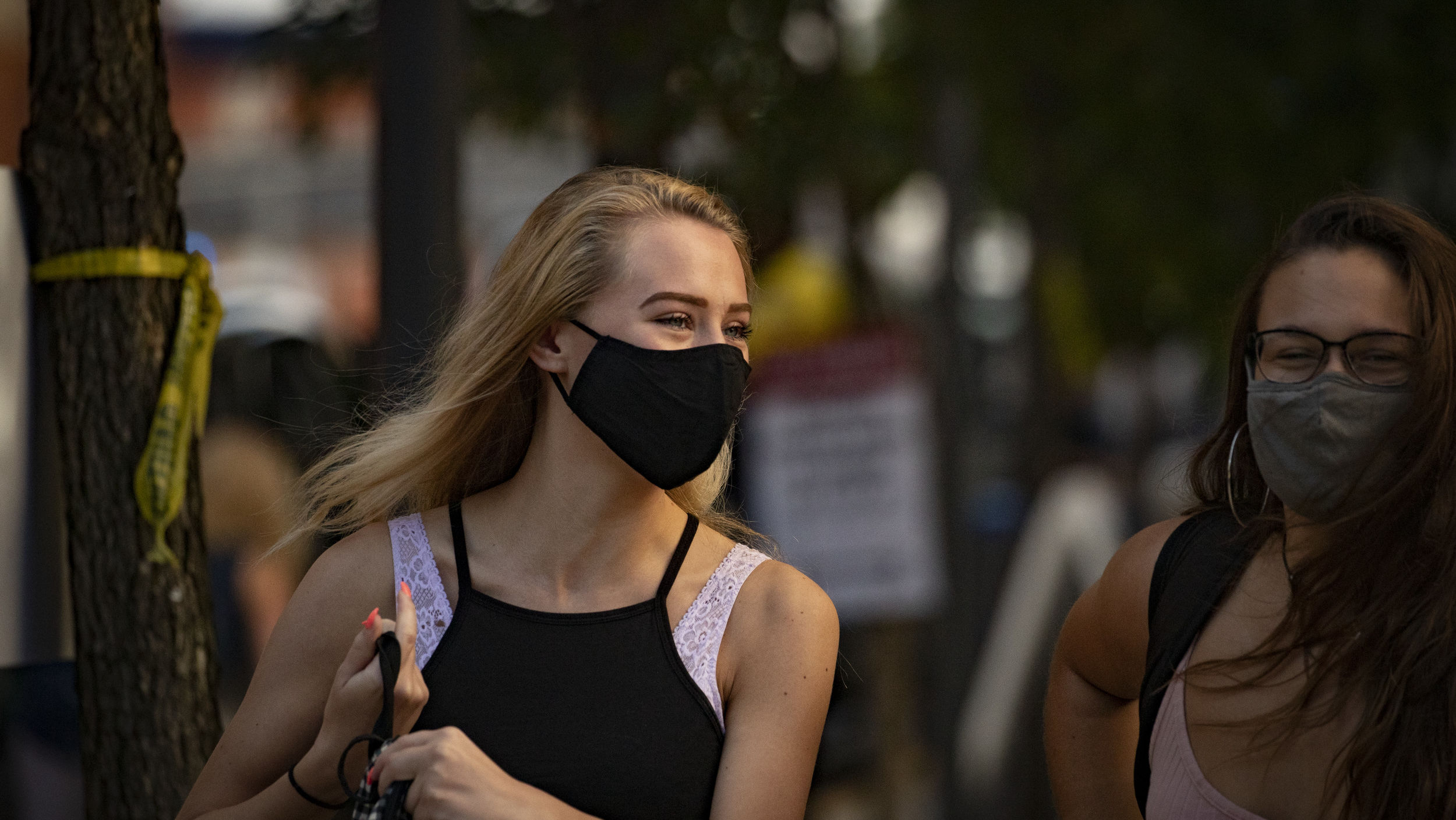 Two students smiling and wearing masks on campus