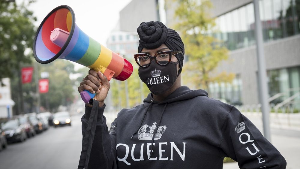 Kendall Stephens wearing a sweatshirt and matching face mask that says "QUEEN" with a rainbow megaphone.