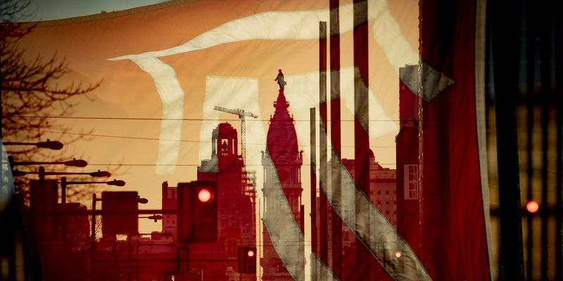 A Temple flag is seen superimposed over City Hall’s William Penn statue.