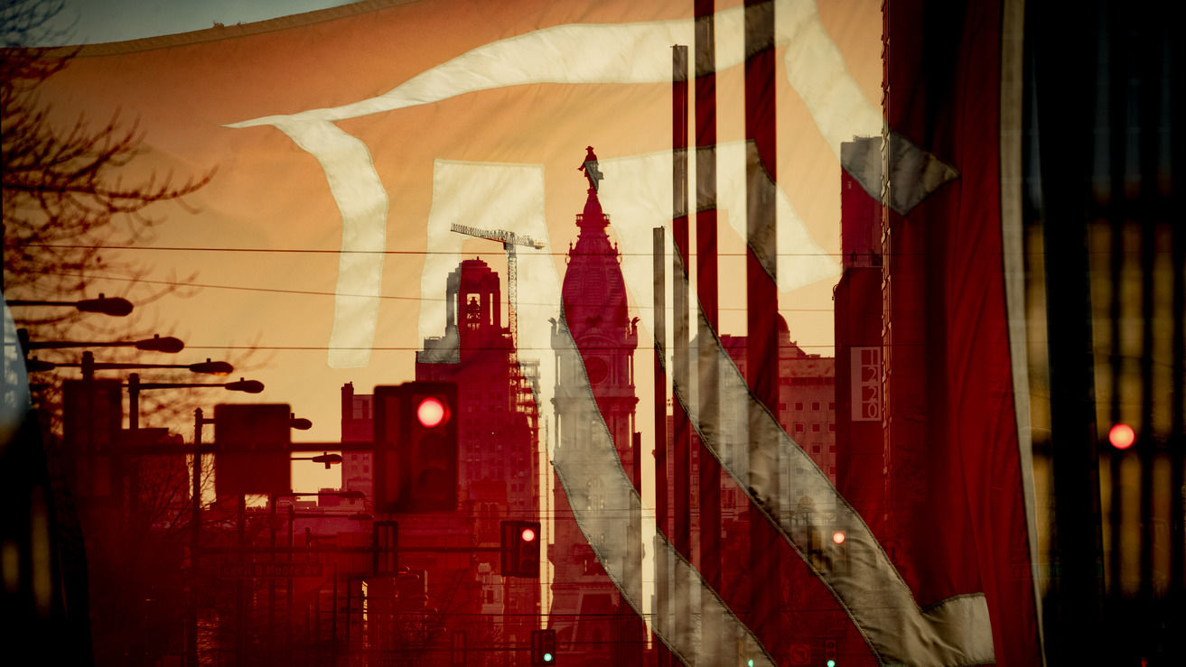 A Temple flag is seen superimposed over City Hall’s William Penn statue.