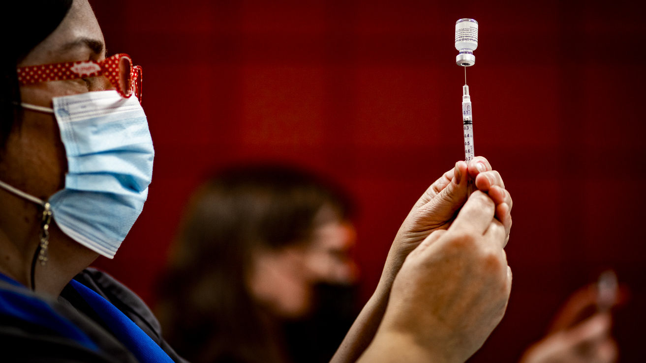 An staff member from Student and Employee Health Services gets ready to administer the COVID-19 vaccine.