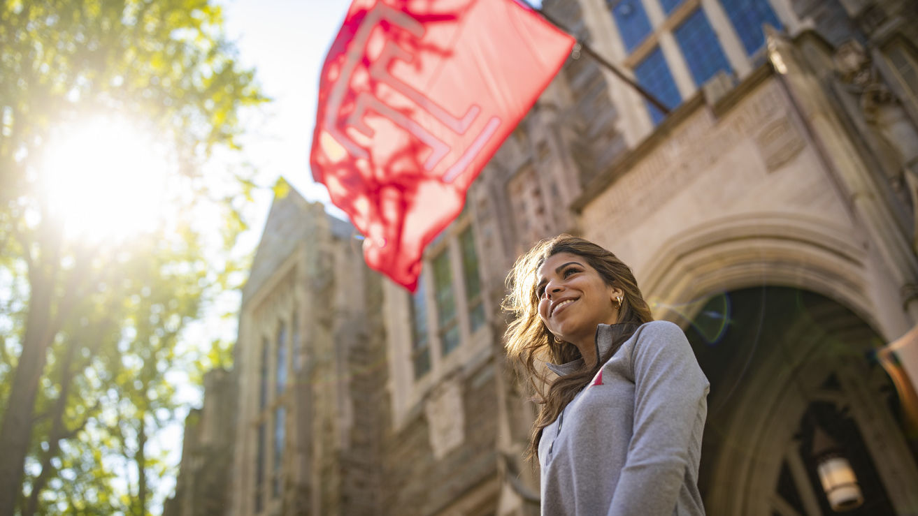 Jennifer Sierra standing under a Temple flag.