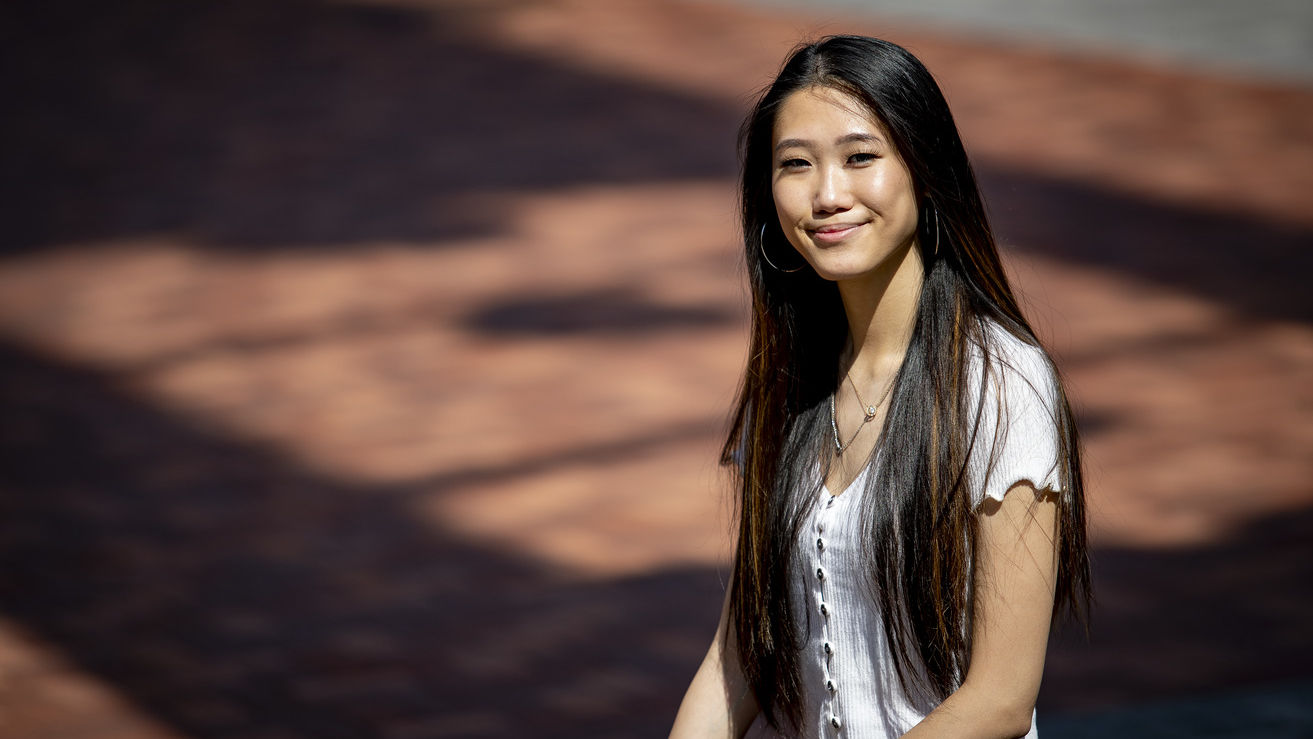 Michelle Wu wearing a white shirt and smiling outside of a building.
