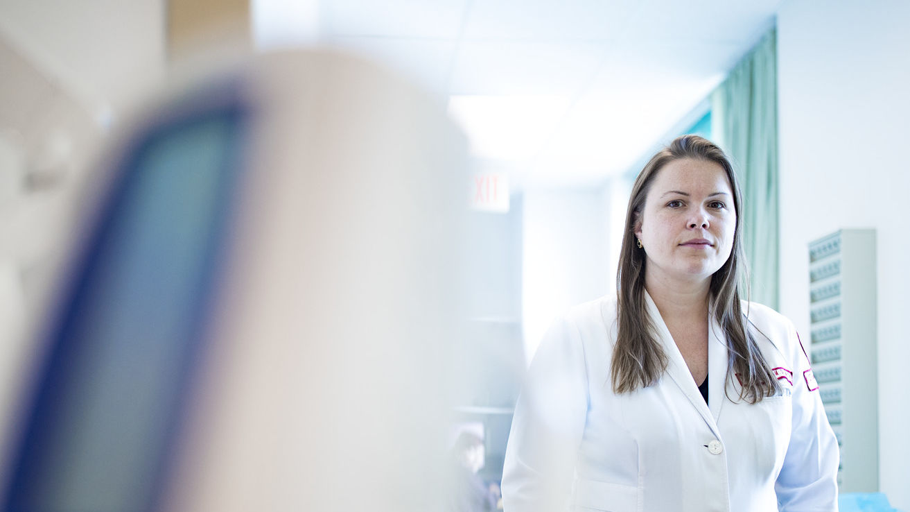 Jessica Beard wearing her white coat inside her medical clinic