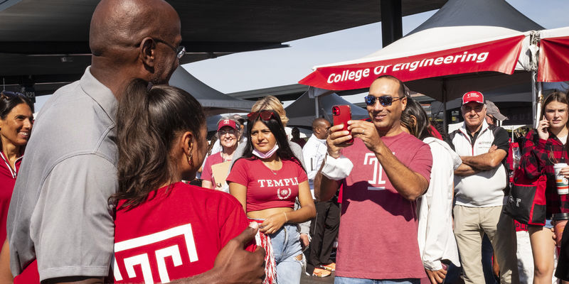  Image of Jason Wingard with a girl wearing a Temple cherry and white tee shirt.