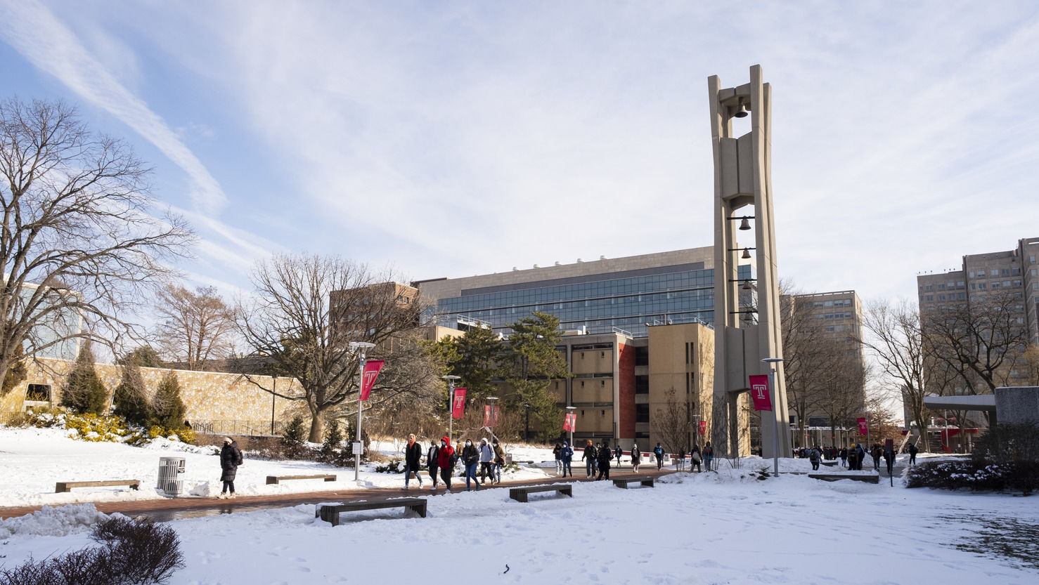 Students walking outside in the snow near the Bell Tower.