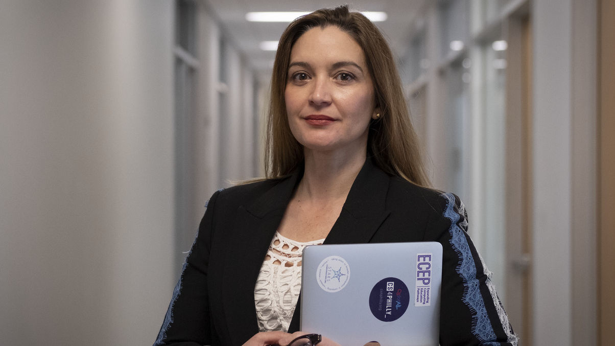 Image of Jamie Payton standing with her laptop in hand.