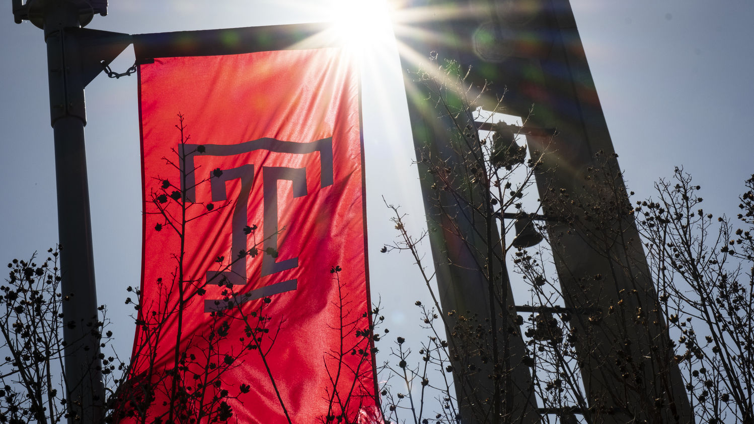 Campus stock of the Bell Tower and a Temple flag.