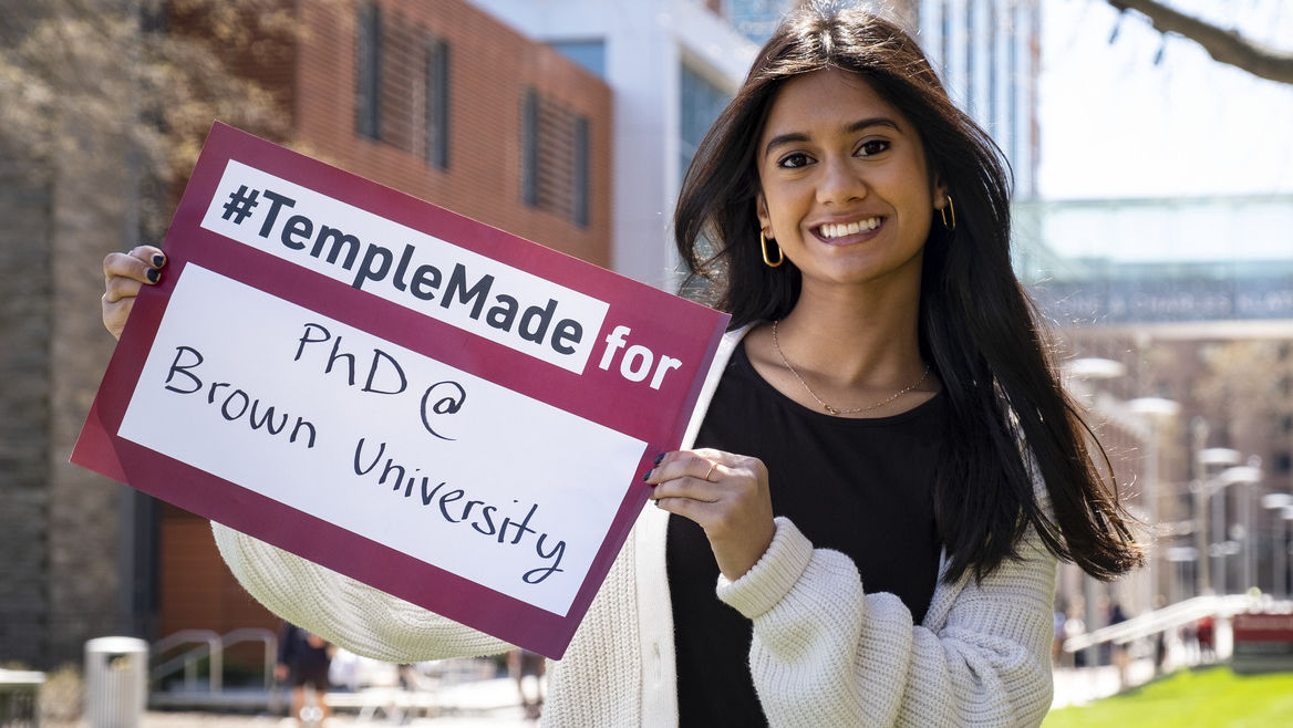 Image of Areebah Rahman outside holding a Temple Made for sign.