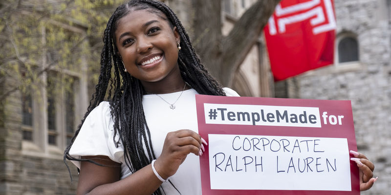 Rachel Edwards holds a sign reading Temple Made for Ralph Lauren