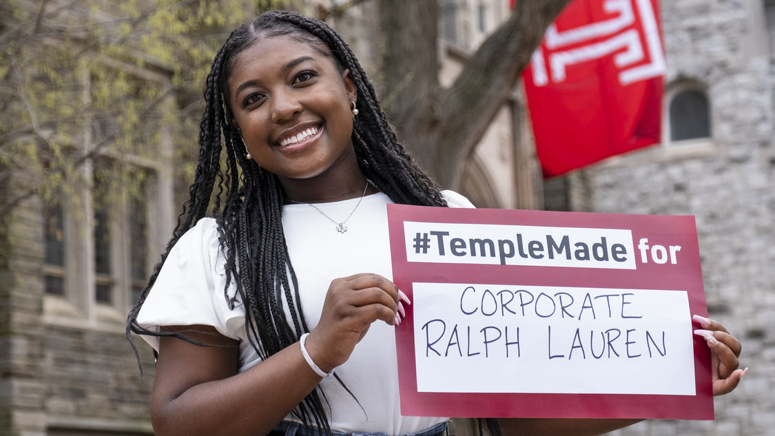 Rachel Edwards holds a sign reading Temple Made for Ralph Lauren