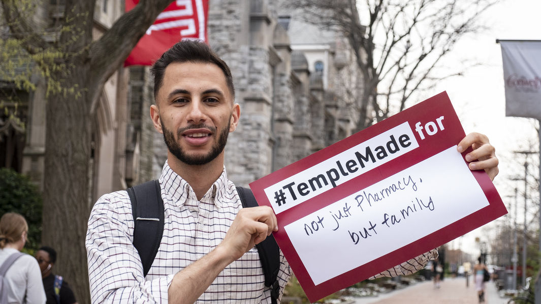 Mohammad Hadaihed holds a sign reading "not just pharmacy, but family"