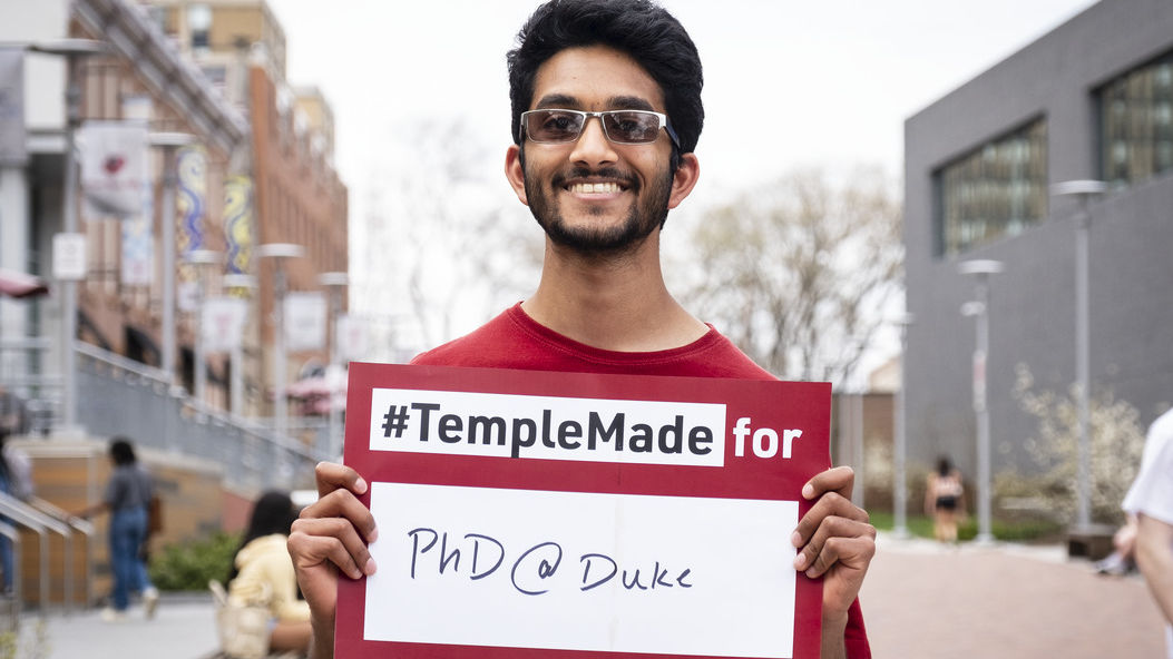 Srikar Katta holding a sign reading Temple Made for PhD@Duke