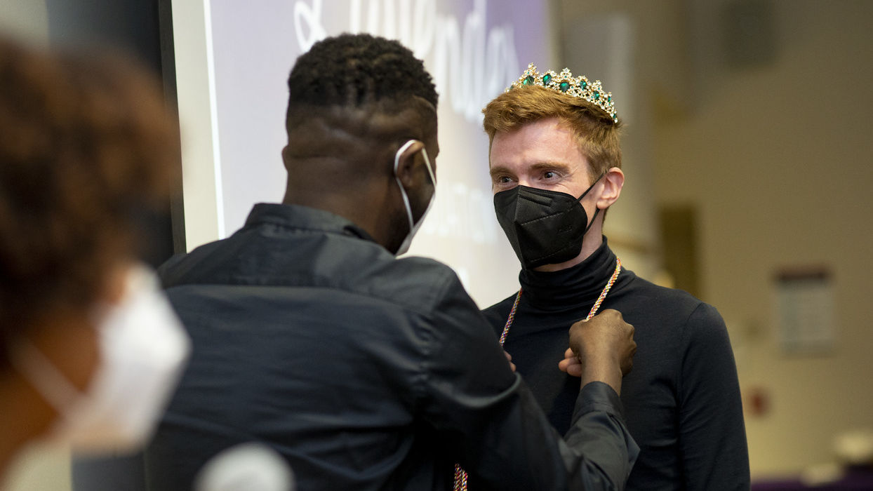 Image of a student in a crown getting rainbow cords.