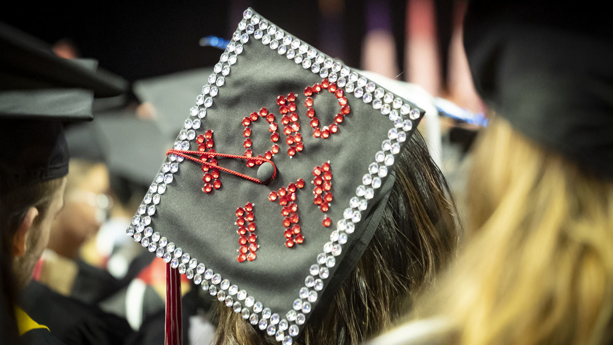 A student’s graduation cap with “I did it!” written in rhinestones. 