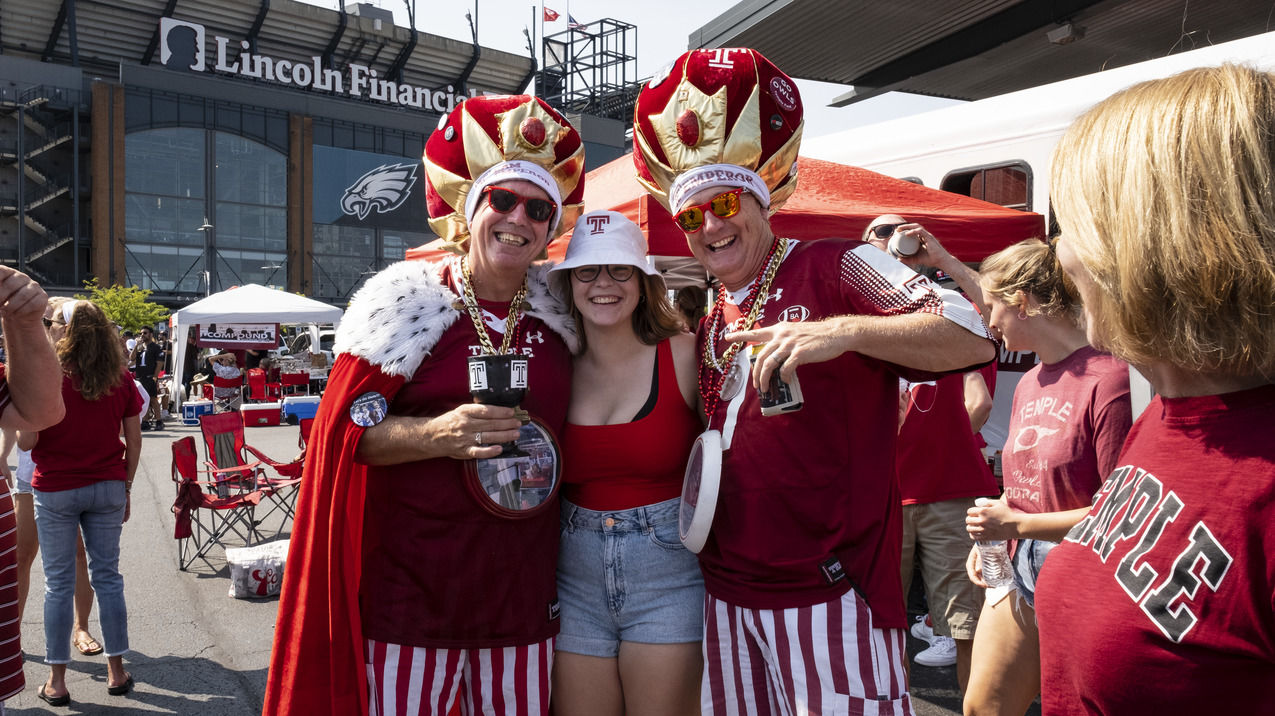 People wearing cherry and white shirts at a Temple University homecoming event. 