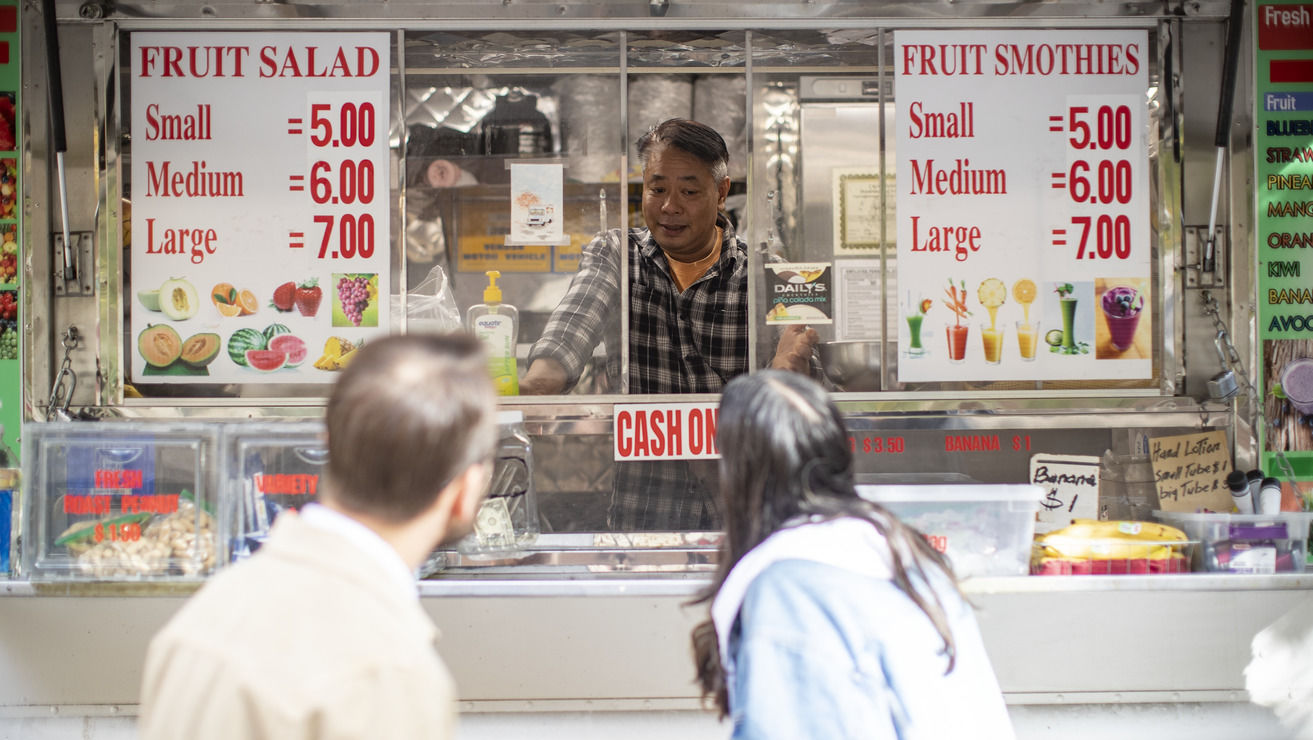 Image of students interviewing a food truck operator.