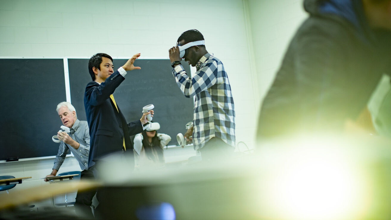 mage of Di Liu demonstrating virtual reality technology with teachers and students in a classroom.     