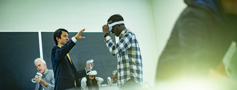 mage of Di Liu demonstrating virtual reality technology with teachers and students in a classroom.     
