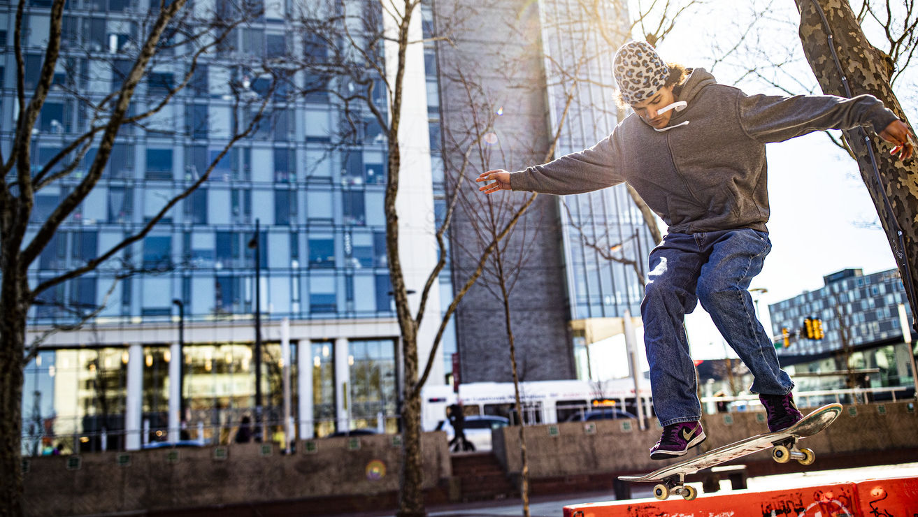 A man skateboarding on a safety barrier