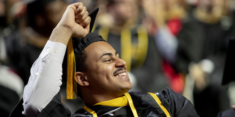 Student at Commencement pumping his hand in the air