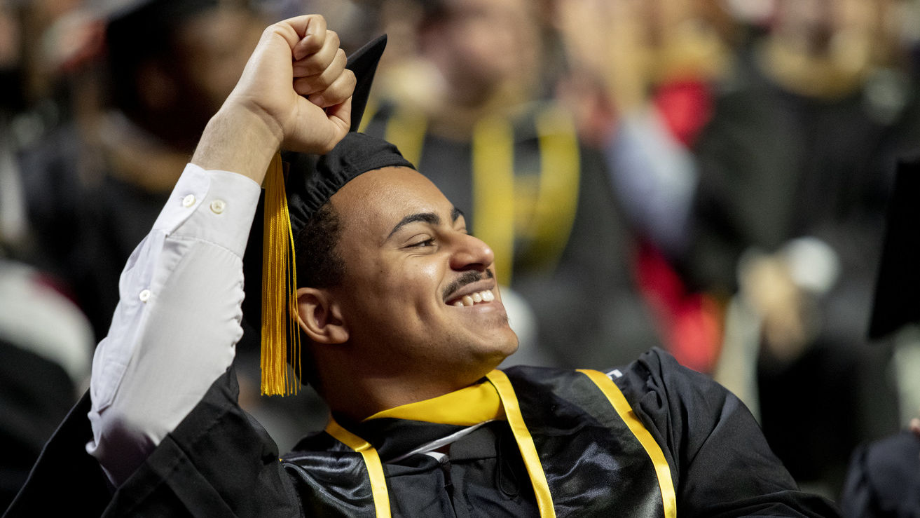 Student at Commencement pumping his hand in the air