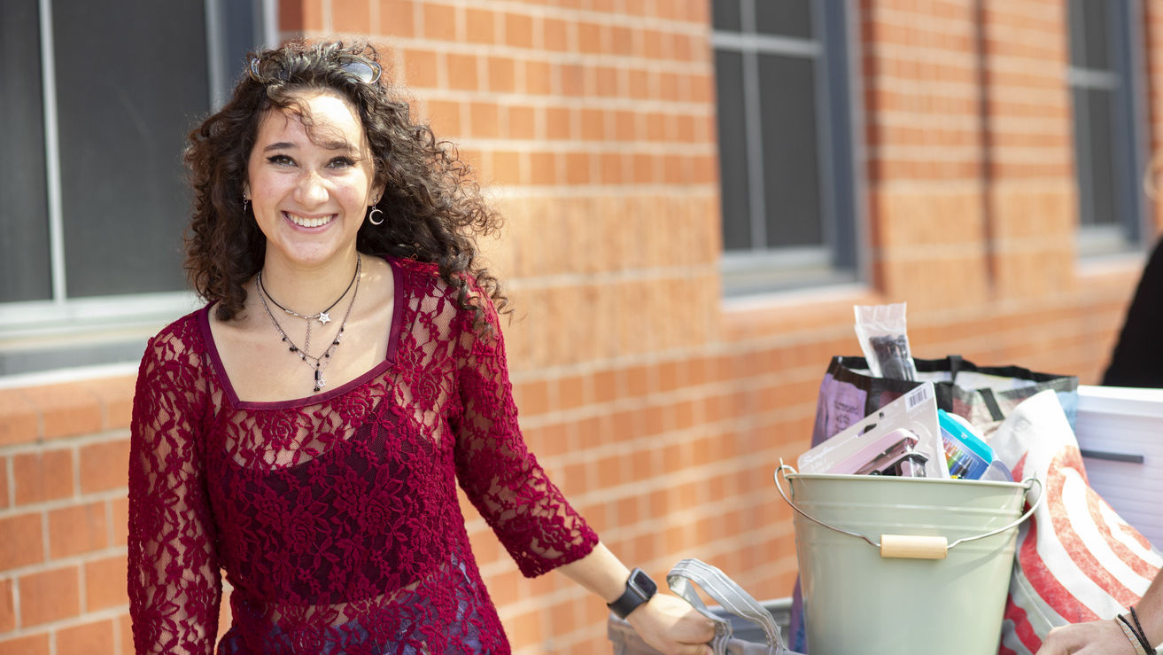 a student smiles while moving out