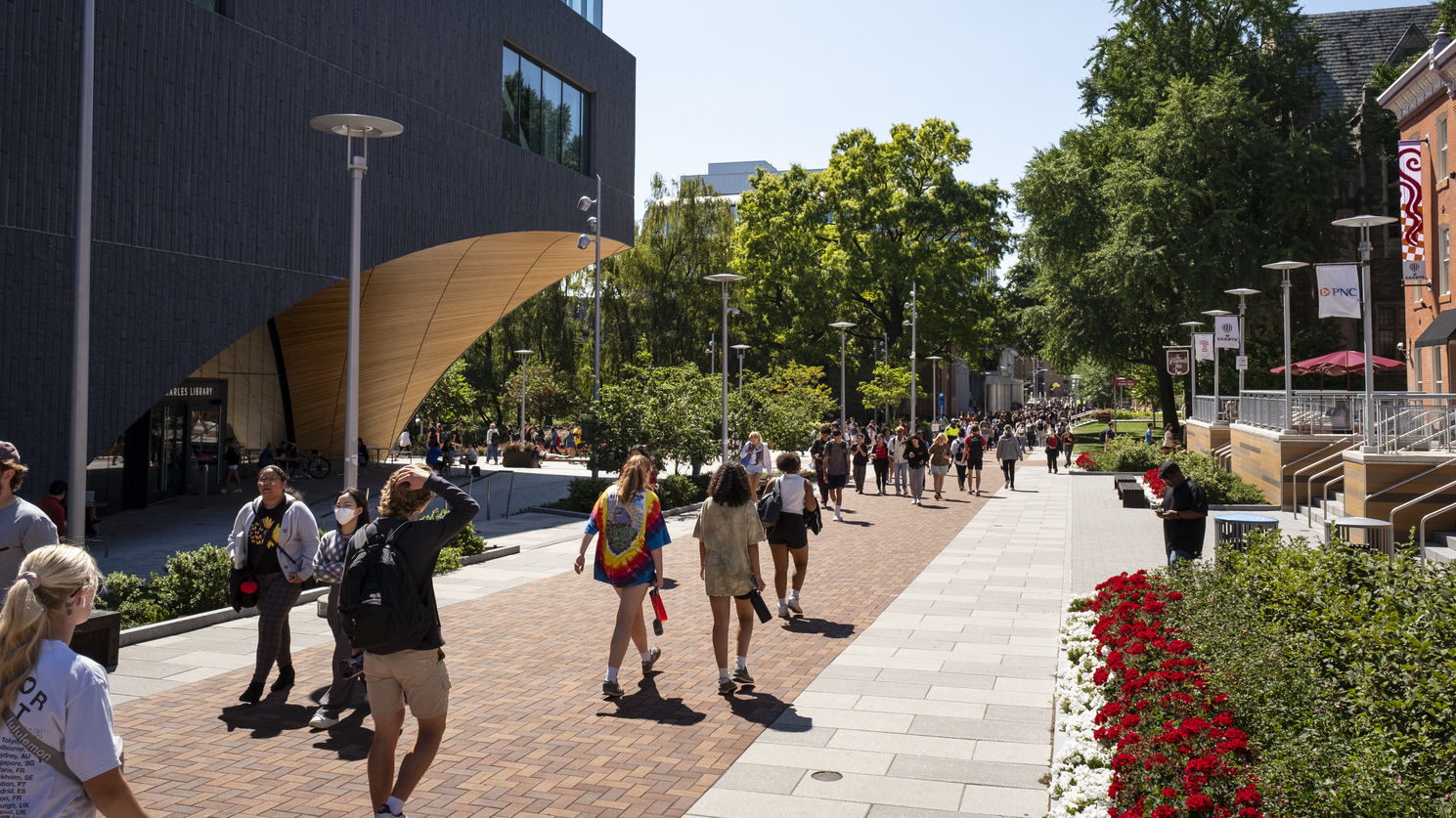 Students walking toward the Bell Tower on a sunny day.