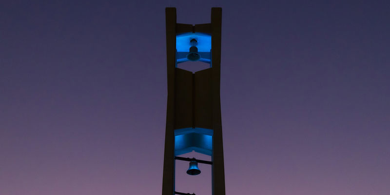 The Bell Tower at night lit up in teal