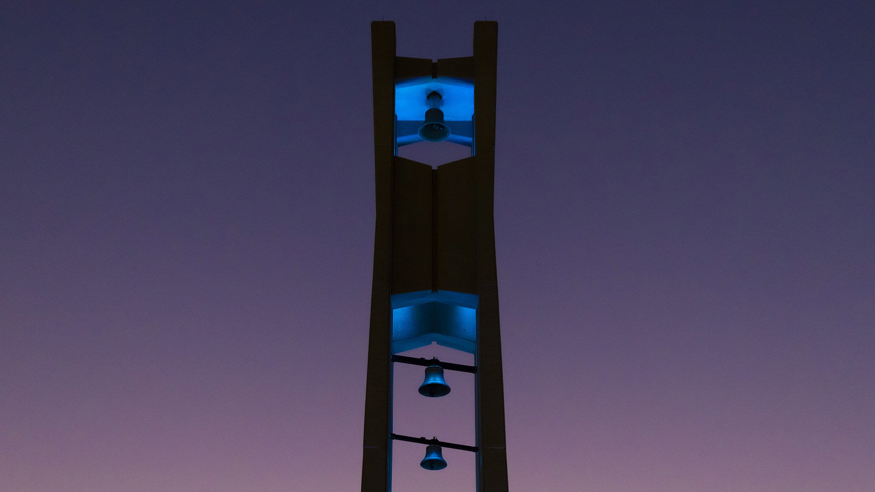 The Bell Tower at night lit up in teal