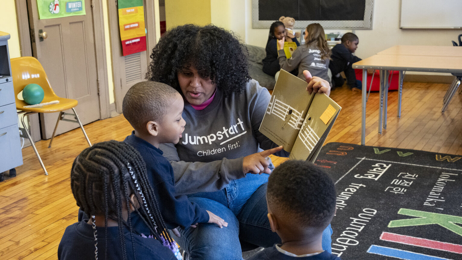 A Temple Jumpstart member reading to preschool children in a classroom at St. Malachy
