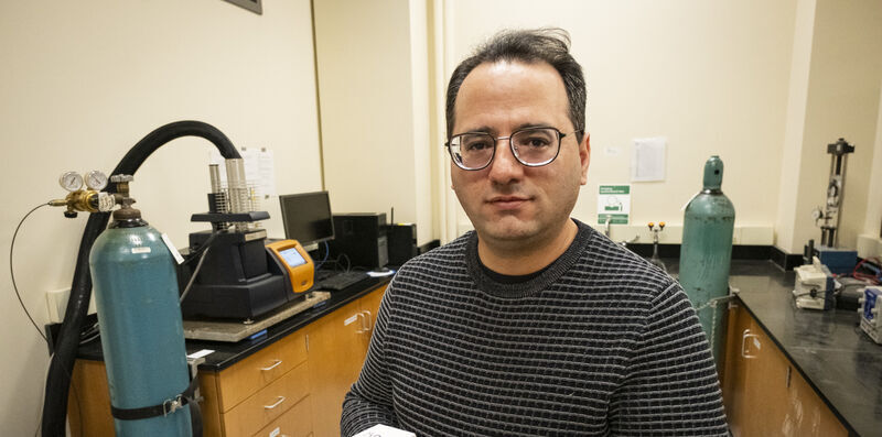 Image of Mehdi Khanzadeh holding a sample of carbonatable concrete.
