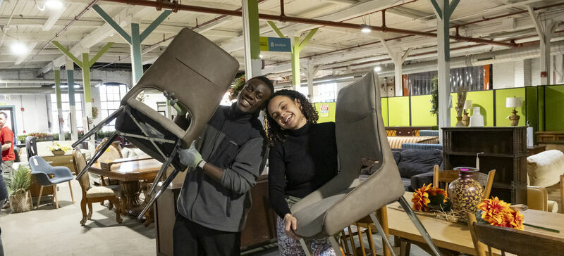 Students hold chairs in a ReStore
