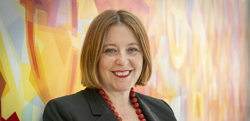 Erika Tapp Duran standing against a colorful background
