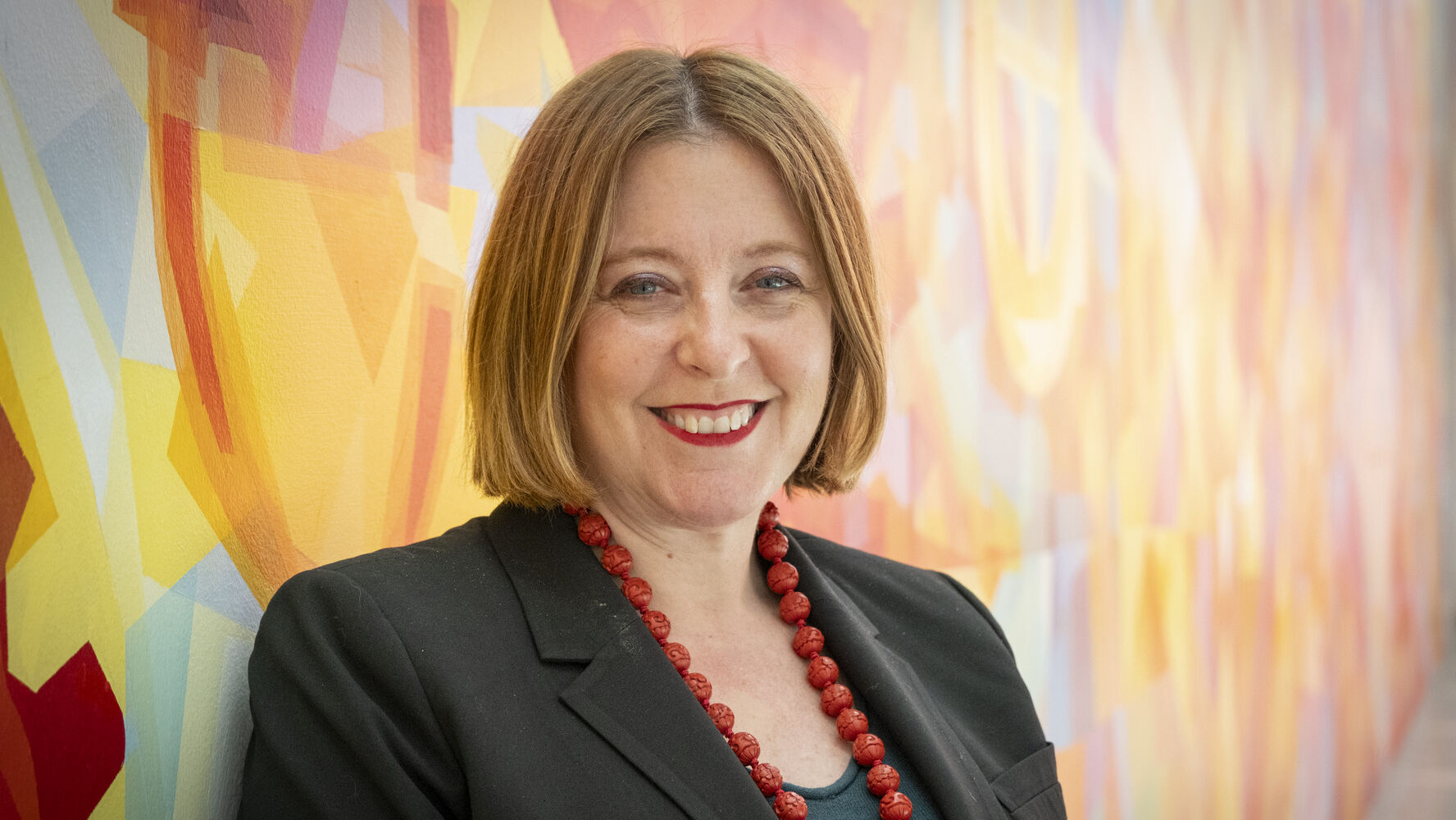 Erika Tapp Duran standing against a colorful background