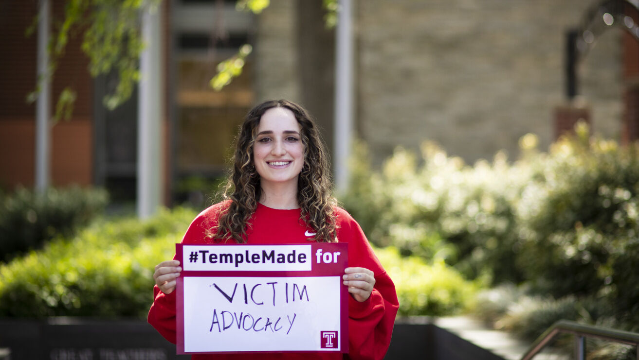 Ray Epstein holding a Temple Made for sign outside of Main Campus