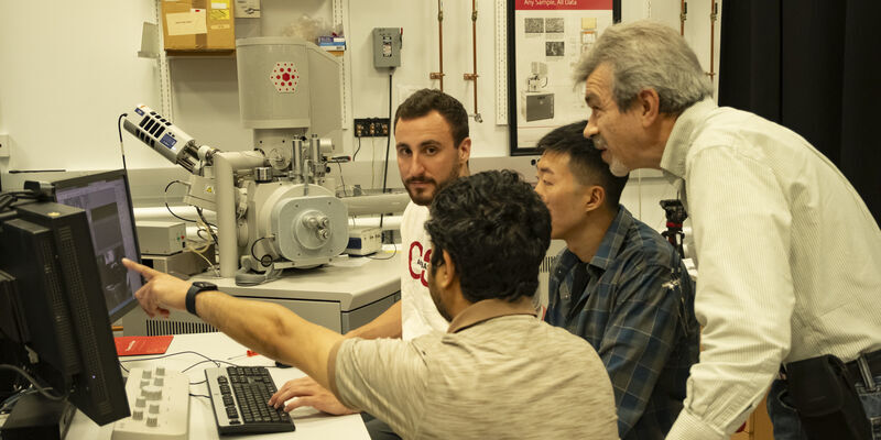 Image of Dmitriy Dikin working alongside researchers.