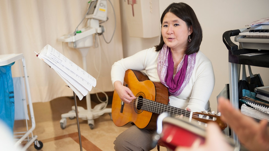 A woman with a guitar in a hospital room