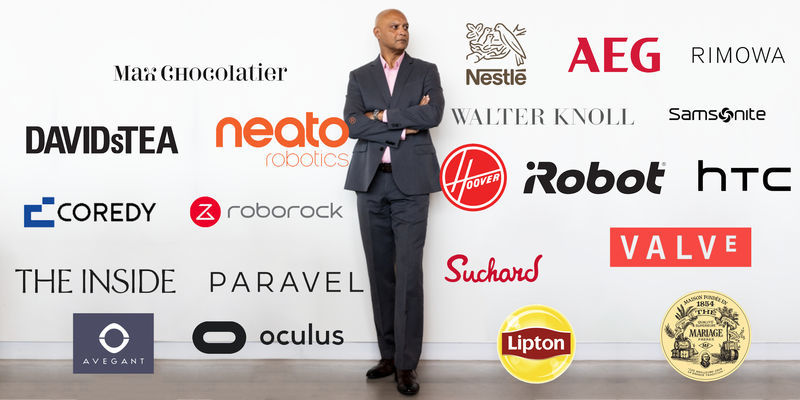 Joydeep Srivastava pictured behind a white wall with tons of brand logos.