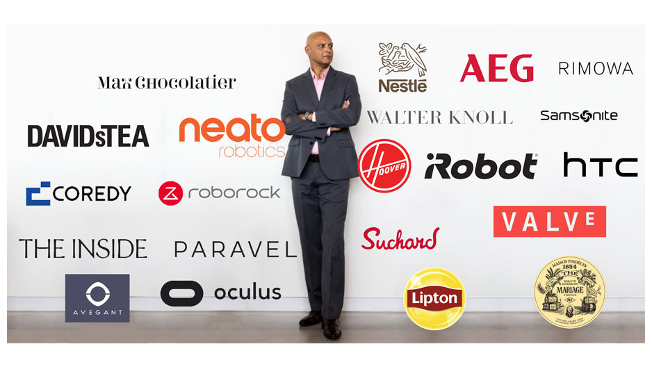 Joydeep Srivastava pictured behind a white wall with tons of brand logos.